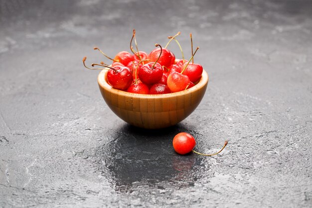 Cerezas maduras en tazón de madera