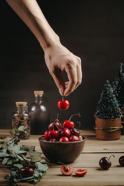 Cerezas en una mesa de madera y adornos navideños