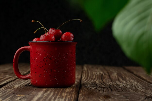 Cerezas en la mesa de madera con gotas de agua