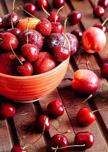 Cerezas y nectarinas frescas en la mesa de madera.