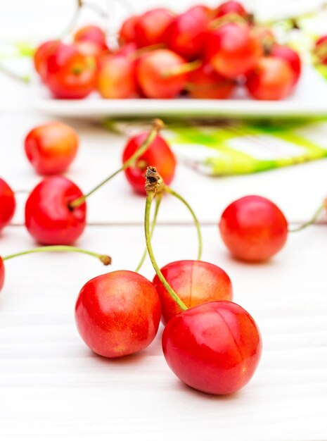 Cerezas y platillo con cerezas sobre la mesa.