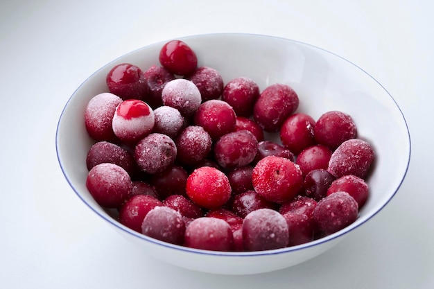 Cerezas rojas congeladas sobre un fondo blanco brillante