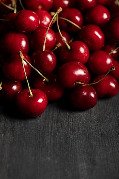 Foto cerezas rojas deliciosas esparcidas de madera