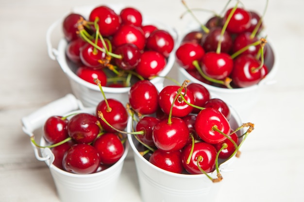 Cerezas rojas dulces aisladas sobre superficie blanca