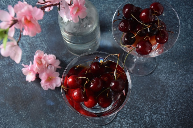 Cerezas rojas dulces en vasos Primer plano de cereza en un vaso con gotas de agua Postre dulce de verano