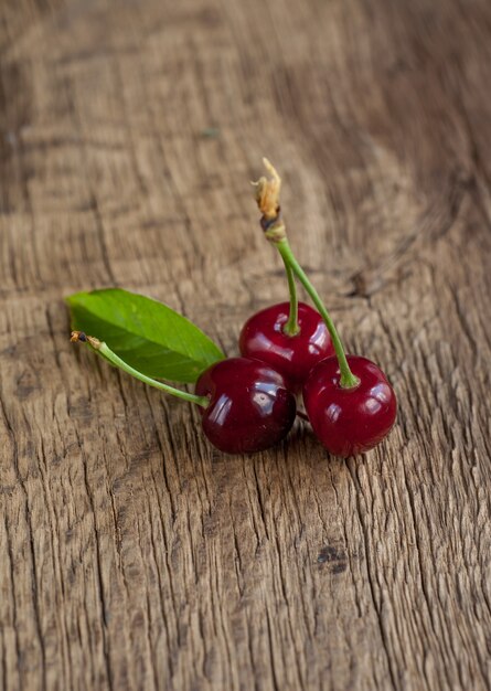 Cerezas rojas frescas sobre fondo de madera