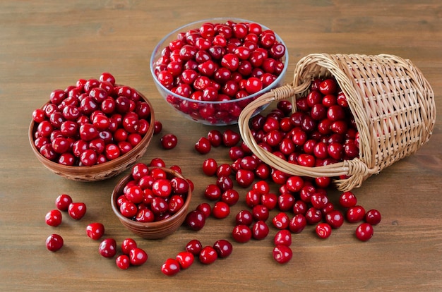 Cerezas rojas maduras en una cesta de mimbre Bodegón sobre una mesa de madera Fondo