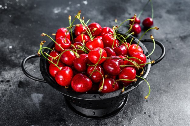 Cerezas rojas maduras en un colador