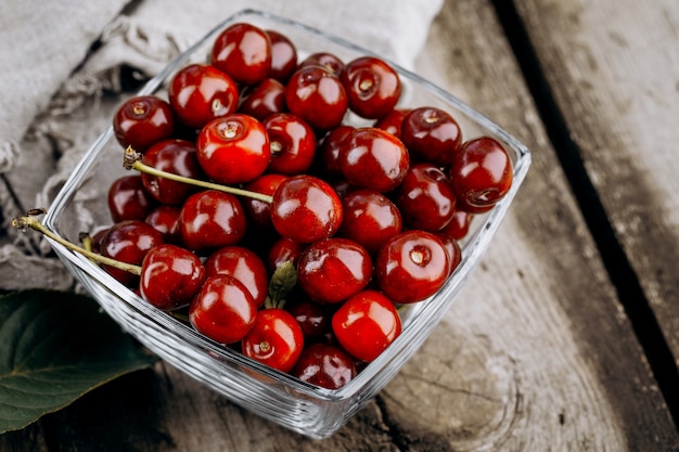 Cerezas rojas maduras en una mesa de madera.