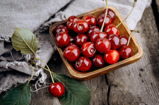 Cerezas rojas maduras en una mesa de madera.