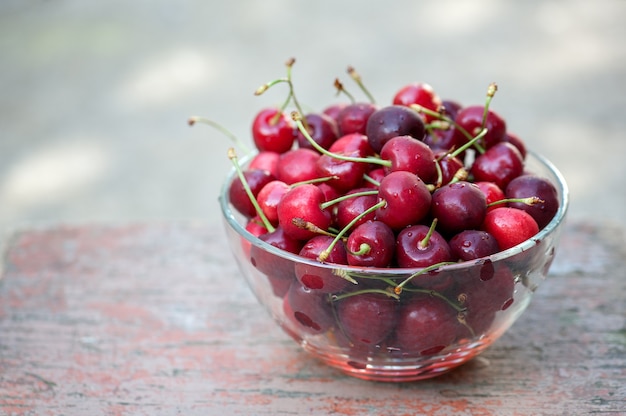 Cerezas rojas maduras en un recipiente de vidrio