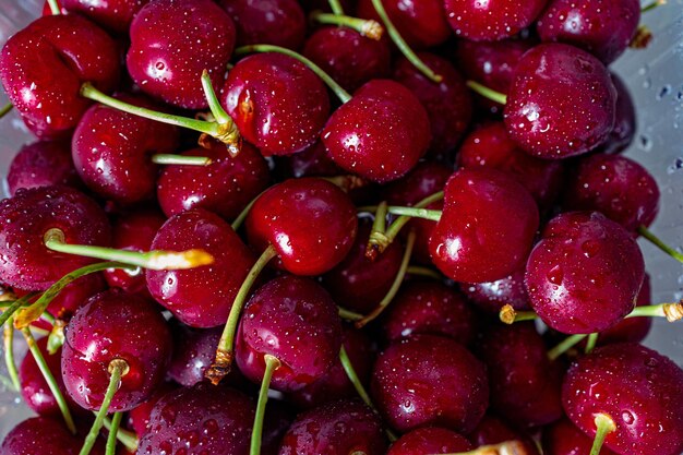 cerezas rojas oscuras con gotas de agua que forman un fondo de verano