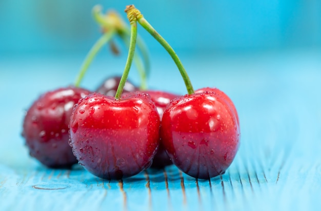 Cerezas sobre un fondo azul de madera