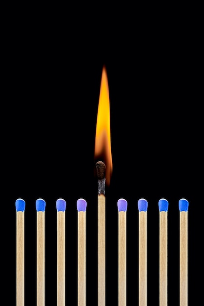 Una cerilla encendida en un grupo de azules coincide con el concepto de liderazgo el surgimiento de una idea