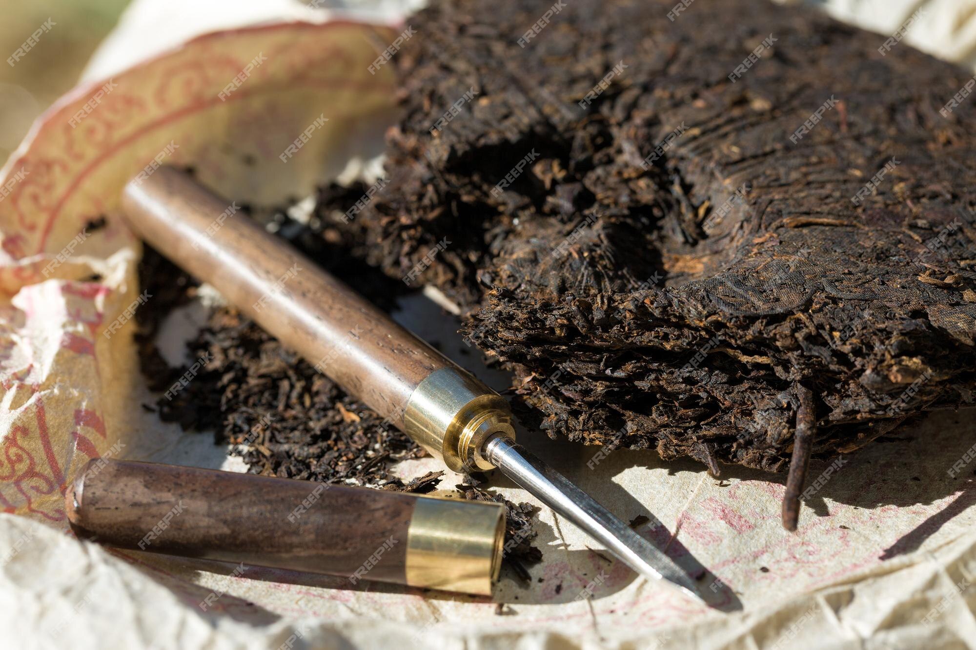 Bolo de chá pu-erh e faca para cerimônia de bebida.