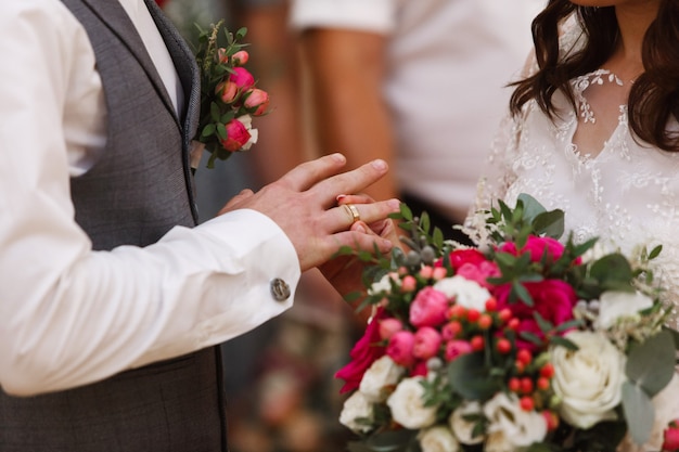 cerimônia de casamento de perto. o casal troca as alianças de ouro. feliz casal recém casado. ela colocou aliança para ele. noiva colocar o anel para o noivo.