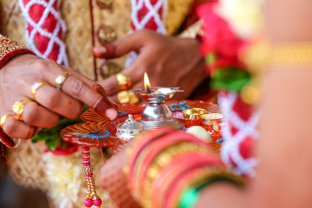 Foto cerimônia de casamento indiano tradicional, noivo segurando a mão da noiva