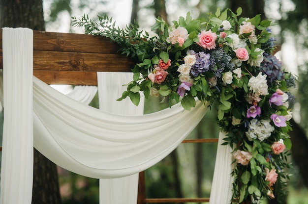 Cerimônia de casamento na rua no gramado verde. decoração com arcos de flores frescas para a cerimônia.