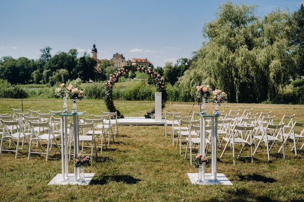 Cerimônia de casamento na rua no gramado verde perto do Castelo de Nesvizh.