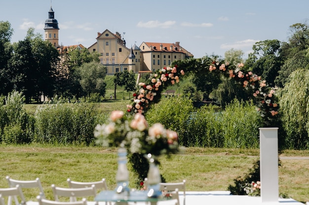 Cerimônia de casamento na rua no gramado verde perto do Castelo de Nesvizh.