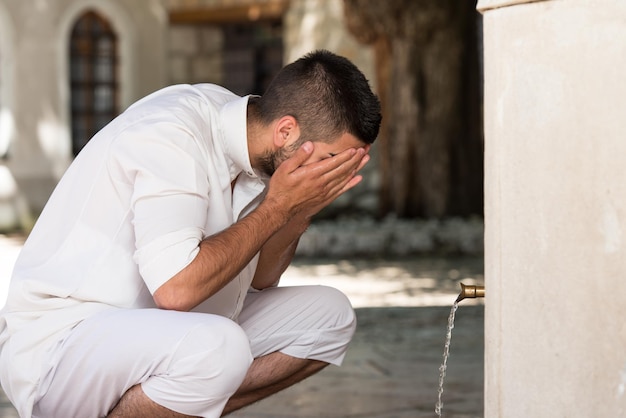 Cerimônia de rito religioso islâmico de lavagem facial de ablução