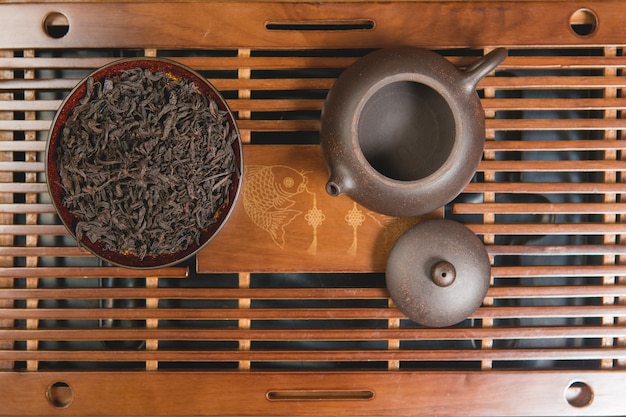 Cerimônia do chá chinês. Bule de cerâmica feito de argila e tigelas em um fundo de madeira.