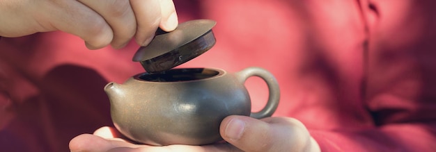 Cerimônia do chá chinês. Bule de cerâmica feito de barro e tigelas em um fundo de madeira.