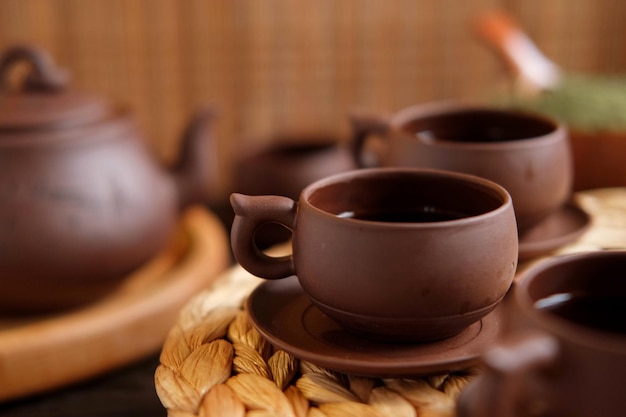 Cerimônia do chá Utensílio de chá tradicional asiático servindo conjunto autêntico Pessoa derramando chá de bule de cerâmica marrom para xícara de chá Bandeja de bambu Estilo de vida Bem-estar Equilíbrio Equipamento de fabricação de chá saudável
