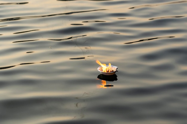 Cerimônia religiosa do hinduísmo puja flores e vela no rio ganges água índia