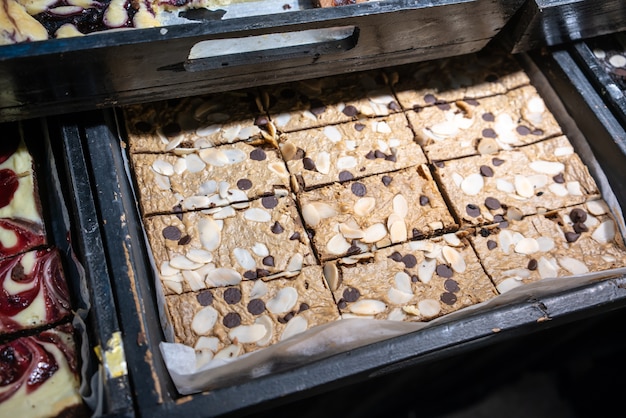 Cerrado Brownie coronado con choc chip y almendra en bandeja de madera