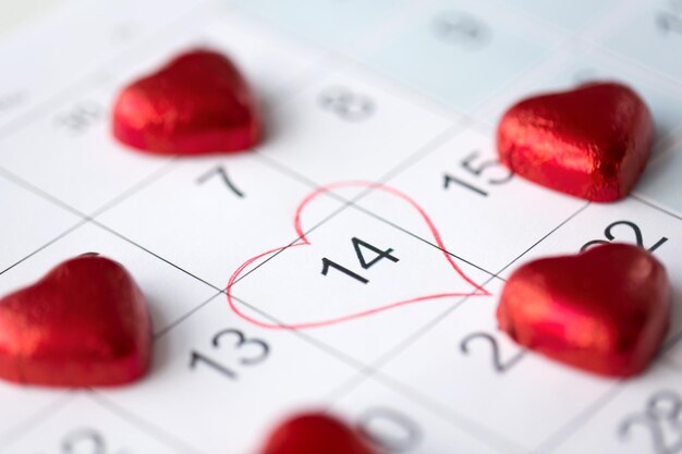 Foto cerrado de calendario y caramelos en forma de corazón