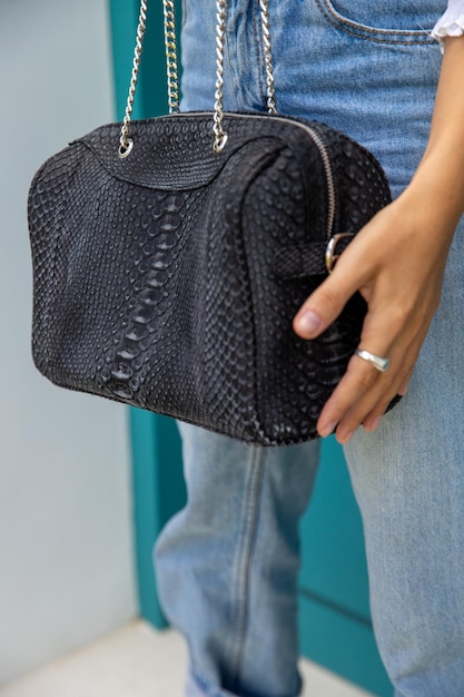 Cerrado de traje de mujer de moda con bolso de cuero con camisa blanca y jeans