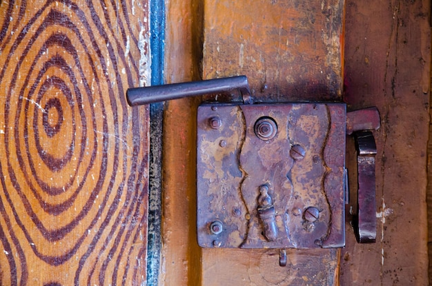 Cerradura de puerta de metal oxidado viejo Puerta de madera en ruinas La entrada al antiguo templo católico Keyhole closeup