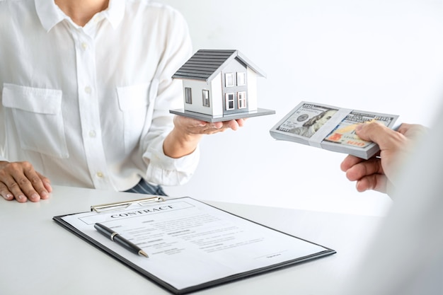 Cerrar agente inmobiliario presentando contrato al cliente