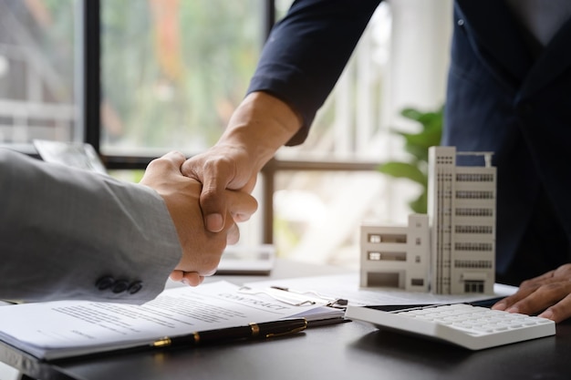 Cerrar un apretón de manos Considerando comprar una casa invertir en bienes raíces Broker firma un acuerdo de venta agente acuerdo de arrendamiento acuerdo exitoso