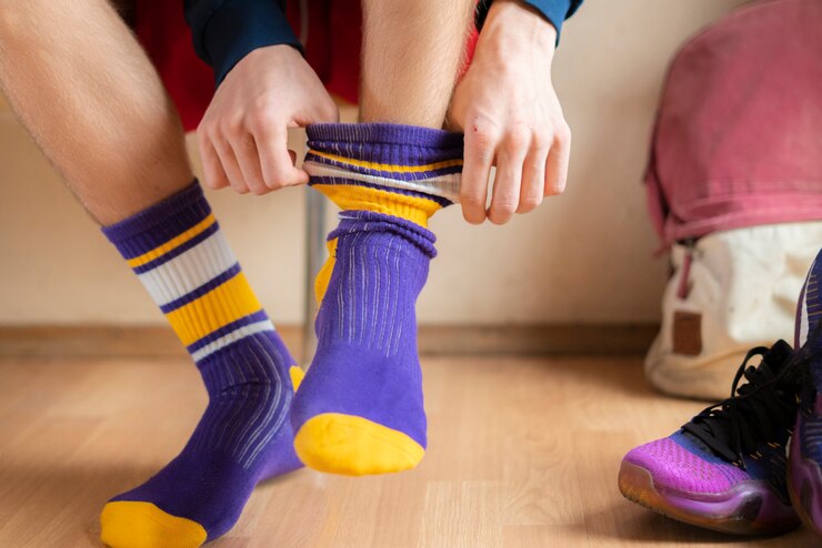 Foto cerrar atleta en vestuario ponerse calcetines y usar ropa deportiva
