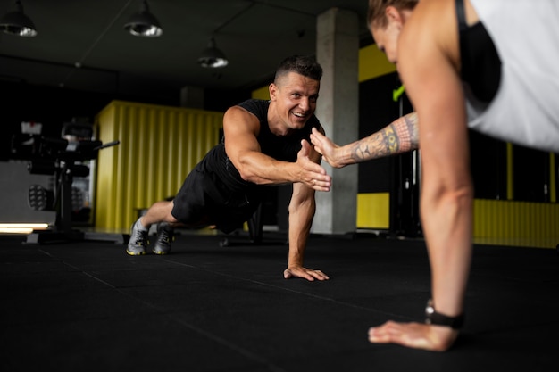 Foto cerrar atletas tomados de la mano en el gimnasio