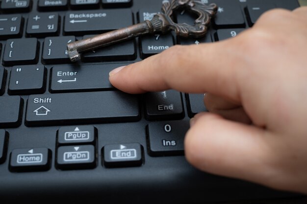 Cerrar el botón pulsador del dedo índice femenino Entrar en el teclado de la computadora