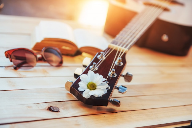 Cerrar la cabeza de guitarra clásica con gafas y libro