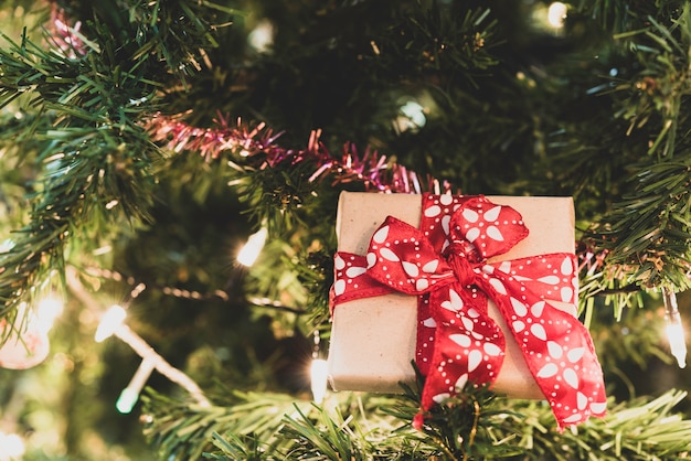 Cerrar caja de regalo de Navidad en pino con cinta e iluminación