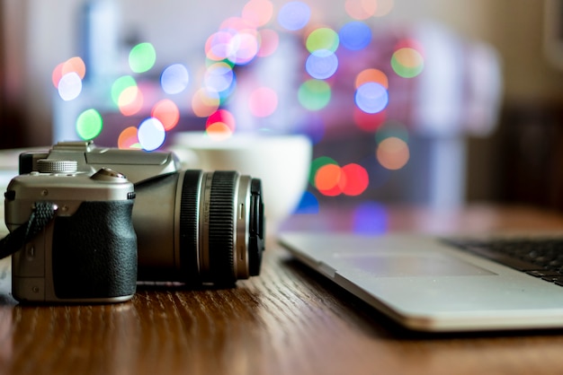 Cerrar cámara en la mesa de trabajo de fotógrafo con laptop