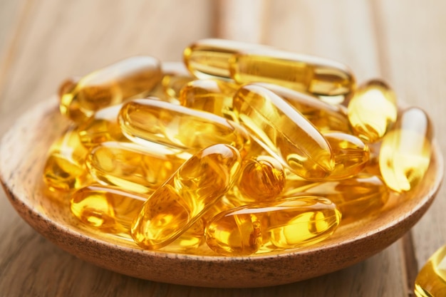 Cerrar cápsulas con vitamina DE o ácidos grasos Omega 369 en botella sobre fondos de madera viejos Suplemento alimenticio aceite de pescado lleno de aceite Suplementos naturales para un concepto de buena vida saludable Banner