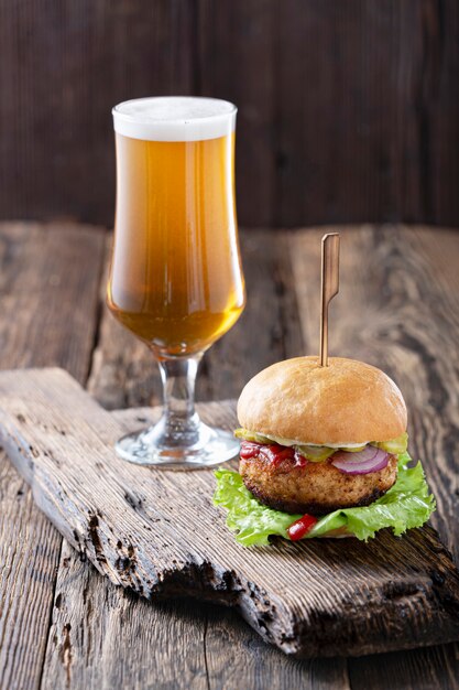 Foto cerrar cerveza y hamburguesa en mesa de madera