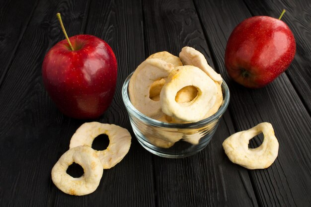 Cerrar en chips de manzana en un tazón de vidrio y manzanas rojas