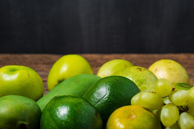 Cerrar colección de frutas verdes en la mesa de madera con espacios en blanco para el concepto de comida de texto