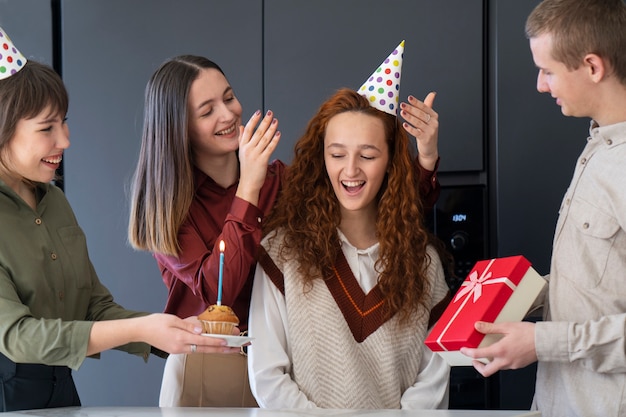 Cerrar colegas celebrando cumpleaños con cupcake