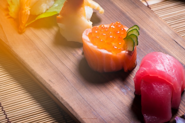 cerrar las comidas japonesas, conjunto de sushi y tetera con sakura en la mesa de madera