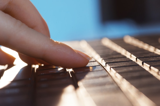 Cerrar los dedos femeninos en el teclado del portátil