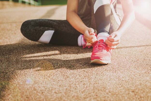 cerrar deporte mujer atar cordón y luz de la mañana