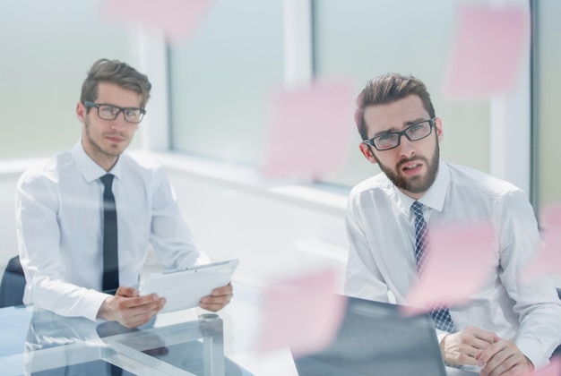 Cerrar dos empleados pensativos sentados en un concepto Deskbusiness